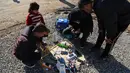 Warga yang melarikan diri dari pertempuran antara pasukan Irak melawan kelompok ISIS mengisi baterai ponselnya di kamp pengungsian Sewdinan, Khazer, Irak, (3/1). Pengisian baterai setiap ponsel dikenakan biaya 500 dinar Irak. (AP Photo / Khalid Mohammed)