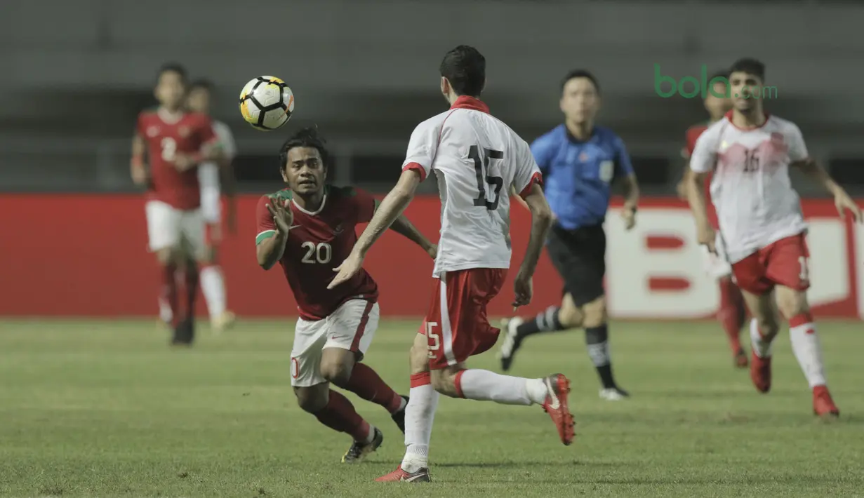 Pemain Timnas Indonesia U-23, Ilham Udin (kiri) berebut bola dengan pemain Bahrain pada laga PSSI Anniversary Cu 2018 di Stadion Pakansari, Bogor, (26/4/2018). Bahrain unggul sementara 1-0. (Bola.com/Muhammad Iqbal Ichsan)