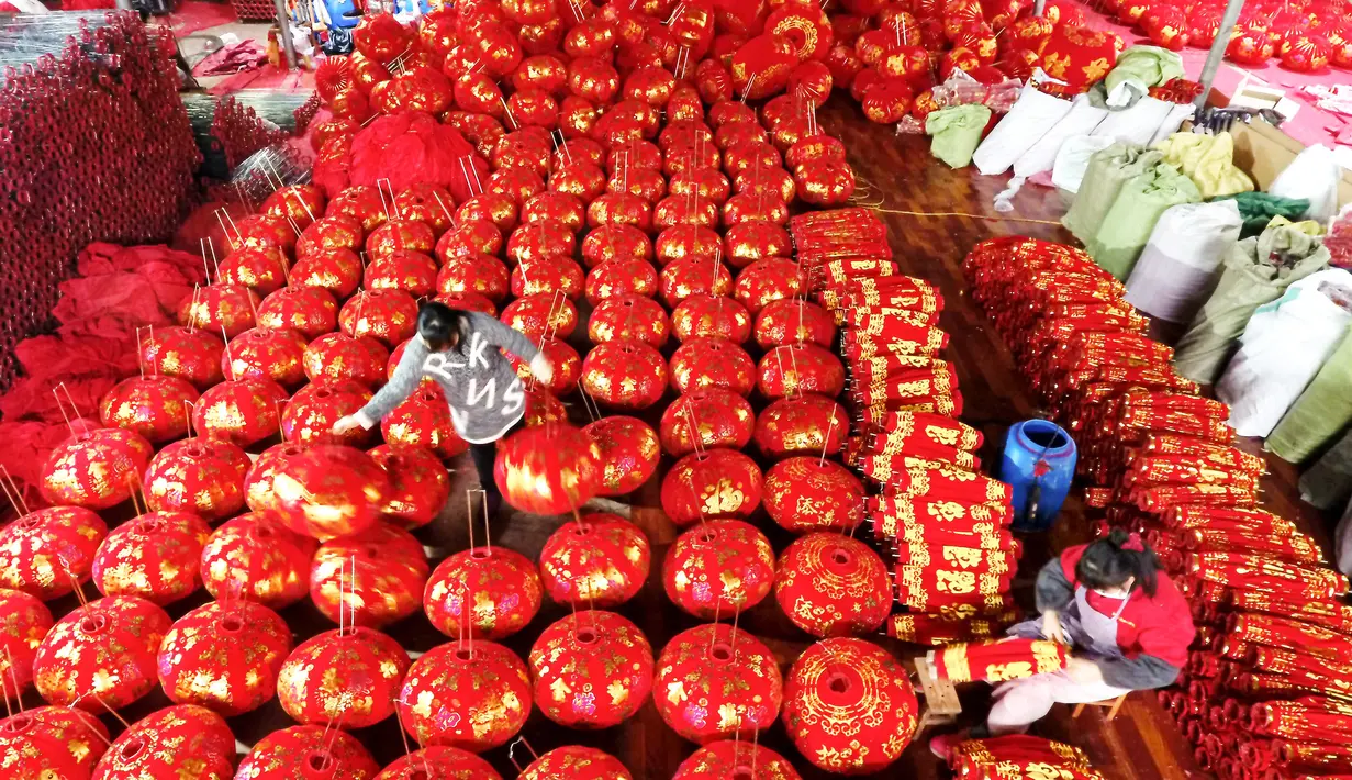 Foto udara memperlihatkan pekerja mengemas lentera merah menjelang perayaan Tahun Baru Imlek 2020 di sebuah pabrik di Wuyi, China, Kamis (26/12/2019). Beberapa keunikan pada tradisi perayaan Imlek yang masih dijalani warga Tionghoa adalah menggantung lentera merah. (Photo by STR / AFP)