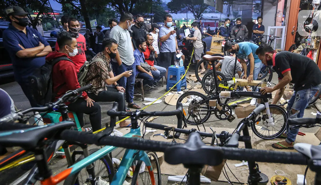 Warga antre menunggu pesanan sepeda yang sedang dirakit di Toko Sepeda Maju Royal, Cipondoh, Kota Tangerang, Kamis (11/6/2020). Menjelang new normal pada 15 Juni, warga mulai berburu membeli sepeda lipat untuk berolahraga dan aktivitas kerja. (Liputan6.com/Fery Pradolo)