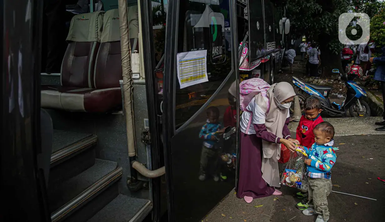 <p>Seorang warga bersama anaknya bersiap menaiki bus tujuan mereka untuk mudik bareng gratis BUMN di kawasan Jakarta, Rabu (27/4/2022). Program mudik gratis merupakan salah satu solusi untuk mengantisipasi potensi kepadatan lalu lintas pada masa Lebaran.(Liputan6.com/Faizal Fanani)</p>