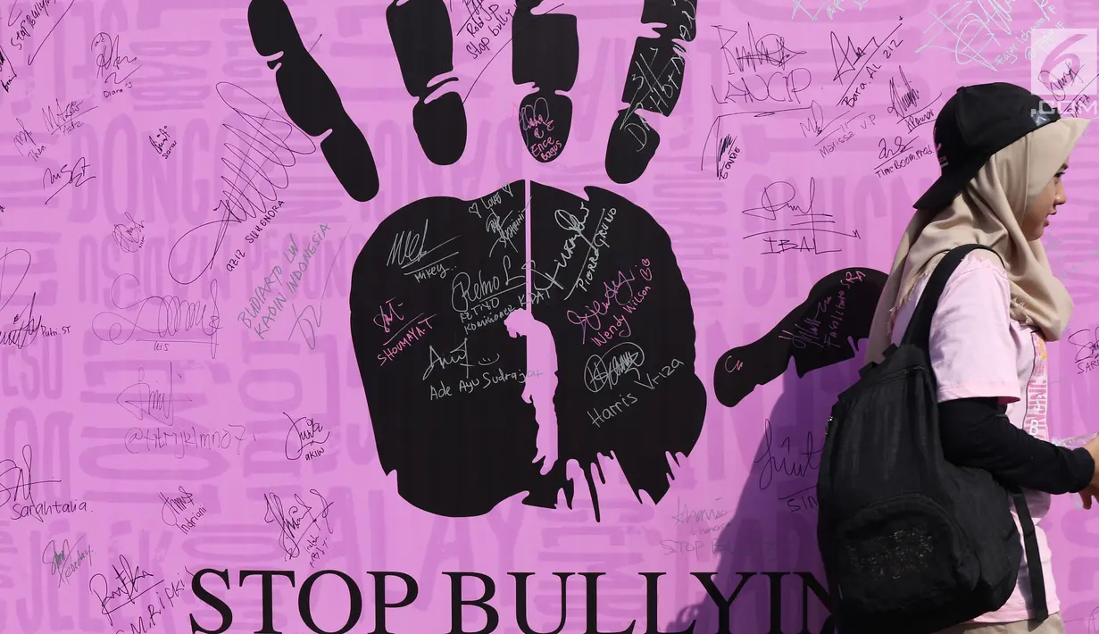 Warga melintas di depan banner tanda tangan dukungan Stop Bullying saat Car Free Day di Bundaran HI, Jakarta, Minggu (13/5). Bullying adalah tindakan mencoba untuk menyakiti atau mengontrol orang lain dengan kekerasan. (Liputan6.com/Helmi Fithriansyah)