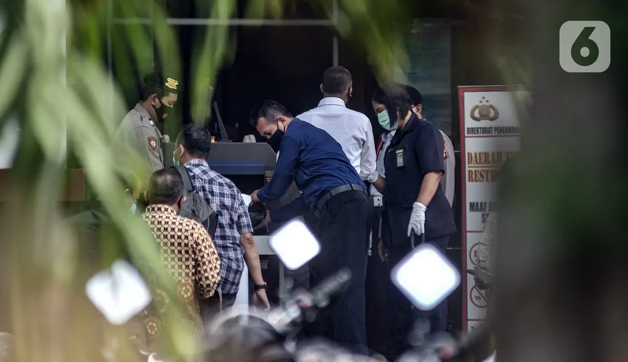Polisi memeriksa barang bawaan pengunjung saat sidang perdana Rizieq Shihab di Pengadilan Negeri Jakarta Timur, Jakarta, Selasa (16/3/2021). Meski sidang digelar secara virtual, polisi tetap menjaga ketat PN Jakarta Timur guna mencegah kerumunan massa. (merdeka.com/Iqbal S. Nugroho)