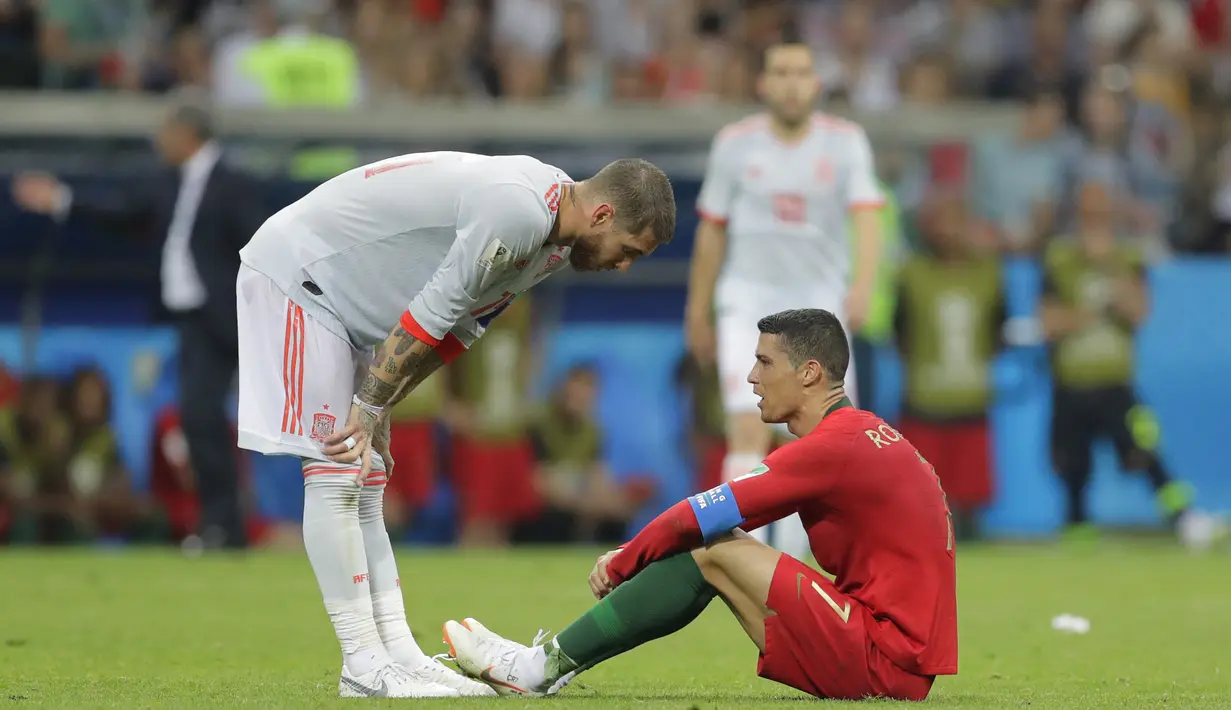Bintang Portugal, Cristiano Ronaldo, dijatuhkan oleh bek Spanyol, Sergio Ramos, pada laga Grup B Piala Dunia di Stadion Fisht, Sochi, Jumat (15/6/2018). Kedua negara bermain imbang 3-3. (AP/Sergei Grits)