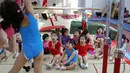 Murid-murid saling membantu saat mengikuti kelas senam lantai di sekolah atletik Shanghai Yangpu Youth Amateur, China (18/5). Sistem sekolah olahraga di China telah sangat membantu meraih kesuksesan dengan didikan kerasnya. (REUTERS/Aly Song)
