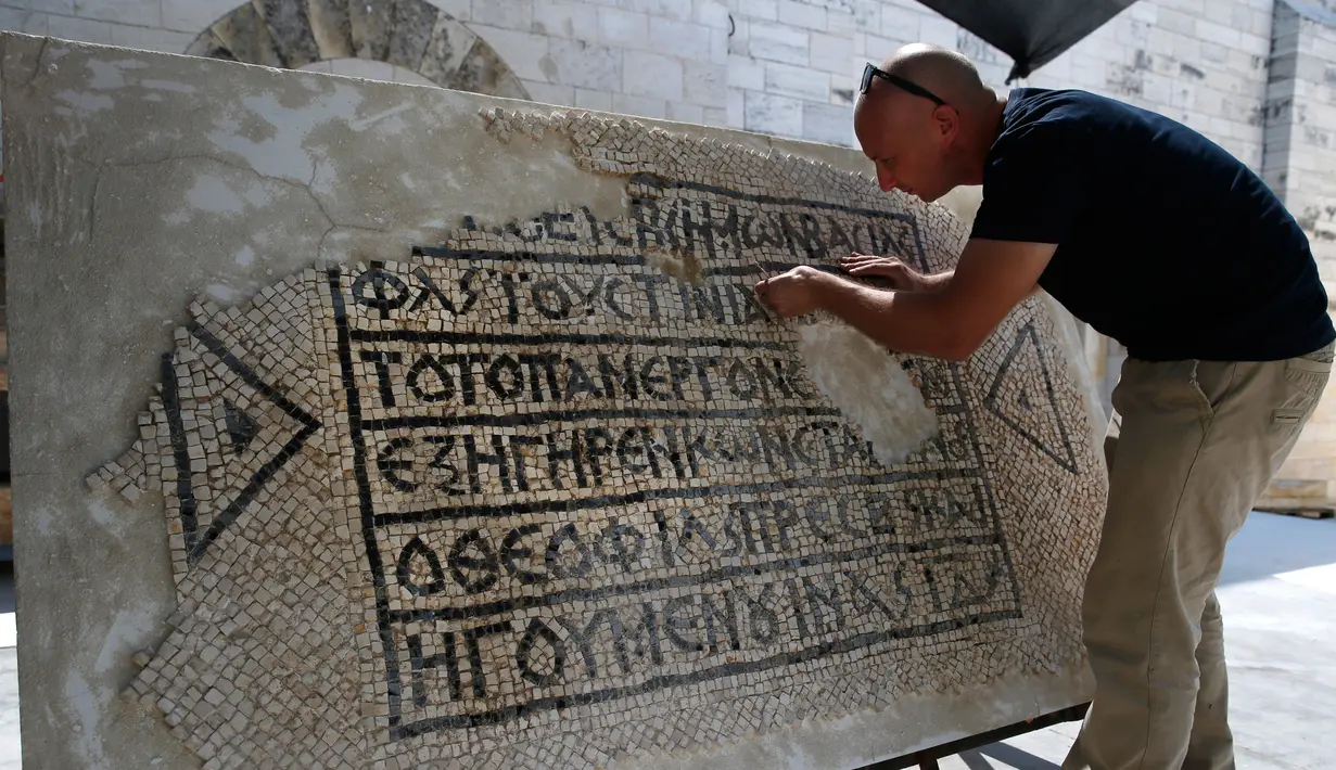 Arkeolog meneliti lantai mosaik berusia 1.500 tahun di Museum Rockefeller, Yerusalem, Rabu (23/8). Arkeolog memercayai prasasti itu akan membantu mereka memahami proyek bangunan Justinian, yang dipersengketakan oleh Israel-Palestina. (AHMAD GHARABLI/AFP)