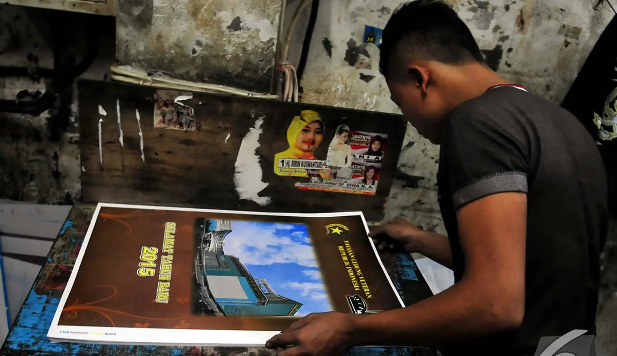 Seorang pekerja melakukan pengecekan hasil cetak di tempat percetakan, Senen, Jakarta, Senin (1/12/2014). (Liputan6.com/Johan Tallo)