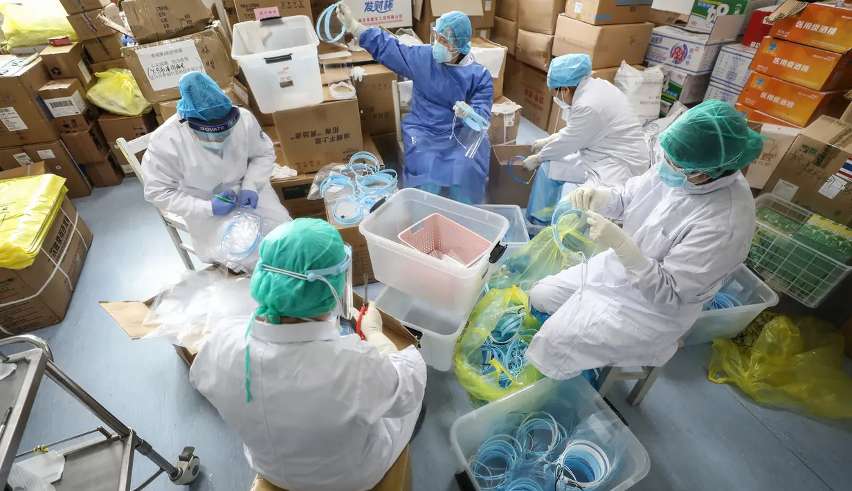 Petugas medis mengenakan masker pelindung di rumah sakit Palang Merah di Wuhan pada 28 Februari 2020. Virus corona baru, Covid-19, telah mewabah hingga ke lebih dari 60 negara dimana dari kasus-kasus infeksi, ada lebih dari 3.000 kematian yang terjadi.  (STR/AFP)