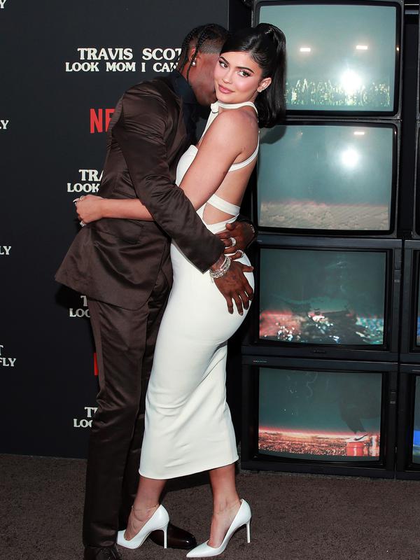 Travis Scott (kiri) mencium dan memeluk Kylie Jenner saat menghadiri pemutaran perdana Netflix 