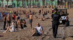 Petugas polisi meminta orang-orang untuk tidak duduk sambil berpatroli di pantai di Barcelona, Spanyol, Rabu, (20/5/2020). Barcelona mengizinkan orang untuk berjalan di pantai untuk pertama kalinya sejak dimulainya penguncian virus coronavirus lebih dari dua bulan lalu. (AP Photo/Emilio Morenatti)