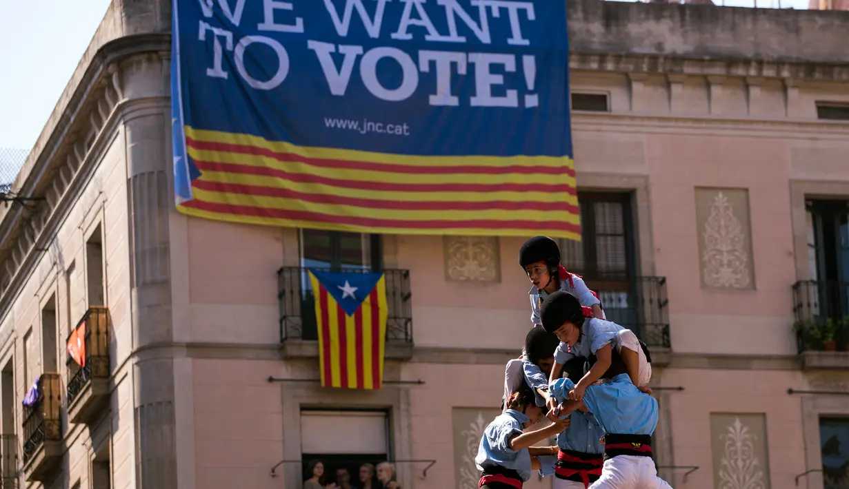 Para Castellers  membangun menara manusia di alun-alun Sant Jaume, Barcelona, Spanyol, Minggu (24/9). Tidak hanya orang dewasa, menara manusia juga terbentuk dari kelompok anak-anak asal Catalonia. (AP Photo/Emilio Morenatti)