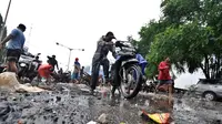 Seorang bapak berusaha menyalakan motornya yang mati akibat melewati banjir, Jakarta, Senin (6/2/2015).  Hujan yang turun sejak malam hingga kini membuat sejumlah ruas jalan tergenang air. (Liputan6.com/Faizal Fanani)