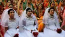 Ratusan pengantin duduk bersama saat nikah massal di Surat, India, Minggu (23/12). Mahesh Savani  telah mendanai pernikahan anak-anak yatim di Kota Surat selama beberapa tahun. (AP/Ajit Solanki)