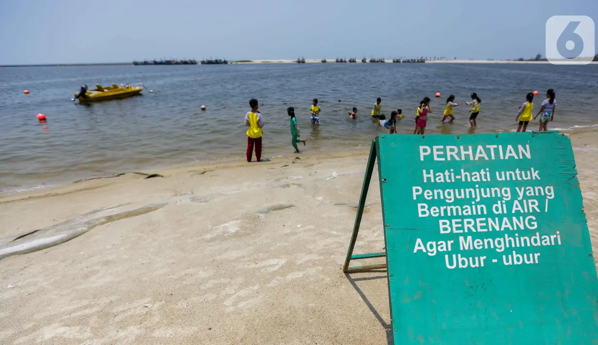 Papan imbauan waspada ubur-ubur terpasang di Pantai Lagoon, Ancol Taman Impian, Jakarta, Rabu (9/10/2019). Kawanan ubur-ubur mulai terlihat di Pantai Lagoon Ancol sejak 6 Oktober lalu. (Liputan6.com/Faizal Fanani)
