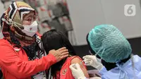 Petugas menyuntikkan vaksin COVID-19 kepada atlet di Istora Senayan, Jakarta, Jumat (26/2/2021). Sebanyak 5.000 atlet diprioritaskan karena mereka dijadwalkan mengikuti beberapa kejuaraan single event maupun multievent dalam waktu dekat. (Liputan6.com/Faizal Fanani)