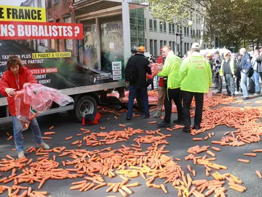 Para penjual tembakau melempar wortel ke jalan saat melakukan aksi protes rencana kenaikan harga sebungkus rokok di Paris, Rabu (4/10). Pemerintah Prancis merencanakan kenaikan harga untuk sebungkus rokok pada 2020 mendatang. (AFP PHOTO/JACQUES DEMARTHON)