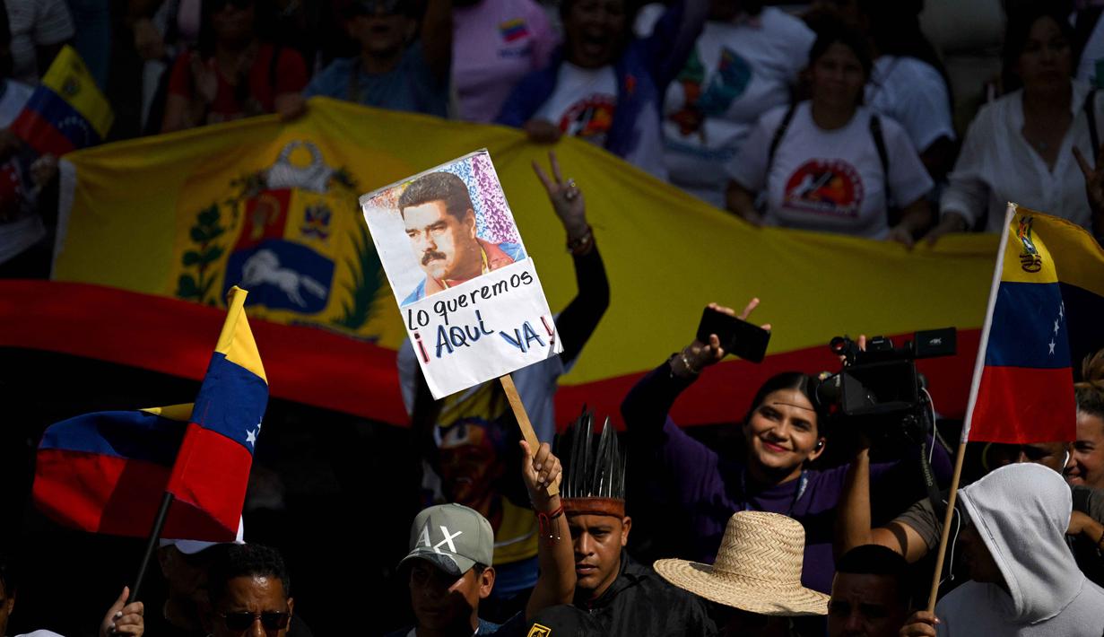 Nicolas Maduro langsung dibawa ke Amerika Serikat dan ditahan di Metropolitan Detention Center (MDC) Brooklyn, New York. Diketahui, Nicolas Maduro telah menjalani sidang perdana di Pengadilan Federal Manhattan pada Senin 5 Januari 2026 dalam kondisi tangan diborgol. Tampak dalam foto, seorang demonstran memegang foto mantan Presiden Venezuela Nicolas Maduro saat unjuk rasa untuk mendukungnya dan istrinya, Cilia Flores, di Caracas pada 6 Januari 2026. (Federico PARRA/AFP)