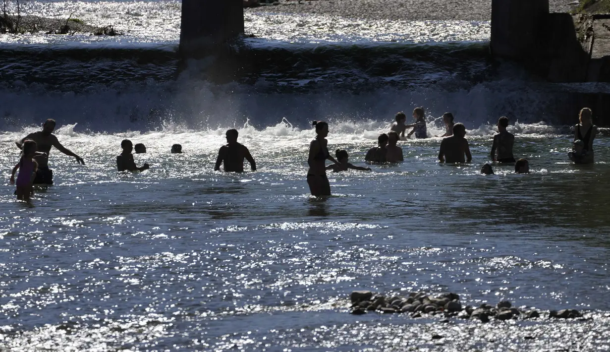 Orang-orang menikmati cuaca musim panas di Sungai Isar, Munich, Jerman, 3 Agustus 2022. (AP Photo/Matthias Schrader)