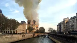 Kebakaran melanda bangunan Gereja Katedral Notre Dame di pusat kota Paris, Prancis, pada Senin (15/4). Kebakaran yang terjadi dengan cepat menghancurkan dua menara persegi katedral, dan mengepulkan asap hitam pekat ke angkasa. (AP Photo/Lori Hinnant)