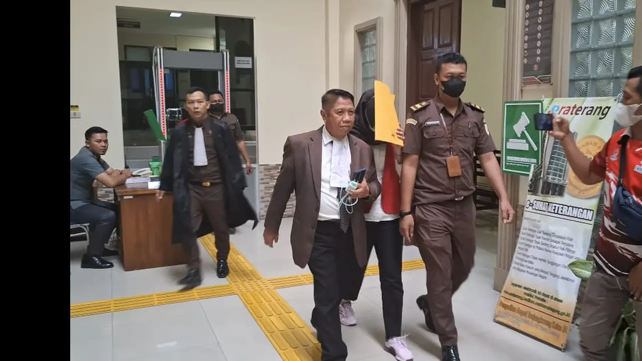 Adelia Putri Salma berupaya menghindari sorotan kamera wartawan ketika menjalani sidang di PN Tanjung Karang. Foto : (Liputan6.com/Ardi)