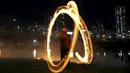 Warga memutarkan kaleng berisi kayu yang dibakar jelang perayaan "Jeongwol Daeboreum"di sebuah taman di Seoul, Korea Selatan, Minggu (21/2). Tarian api ini merupakan bagian dari perayaan Imlek ala Korea. (REUTERS/Kim Hong-Ji)