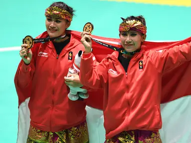 Pasangan pesilat Indonesia, Ayu Sidan Wilantari dan Ni Made Dwiyanti membentangkan bendera merah putih saat merayakan kemenangan usai meraih medali emas nomor seni ganda putri di Padepokan Pencak Silat (TMII, Rabu (29/8). (Merdeka.com/ Imam Buhori)