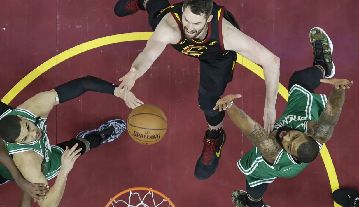 Pemain Cavaliers, Kevin Love (tengah) berebut bola dengan dua pemain Boston pada gim keempat final Wilayah Timur NBA basketball di Quicken Loans Arena (21/5/2018). Cavaliers menang 111-102. (AP/Tony Dejak)