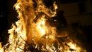 Seorang pria mengendarai kuda melintas kobaran api selama perayaan " Luminarias " di desa San Bartolome de Pinare, Spanyol, (16/1). Luminarias adalah suatu perayaan agama tahunan yang digelar setiap malam di hari Saint Anthony. (REUTERS / Susana Vera)