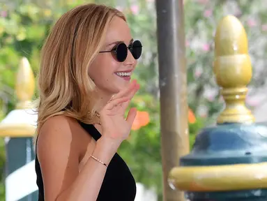 Aktris Jennifer Lawrence menyapa pengemarnya saat tiba di Venice Lido untuk menghadiri Festival Film Internasional Venice ke-74, di Venesia, Italia, (5/9). Jennifer Lawrence tampil cantik mengenakan kacamata dan busana hitam. (Ettore Ferrari/ANSA via AP)