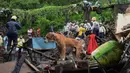 Pasukan Tanggap Bencana Nasional dan tim penyelamat lainnya memeriksa lokasi tanah longsor di daerah kumuh di Mumbai, India, Minggu (18/7/2021). Sebanyak 18 orang tewas setelah beberapa rumah hancur oleh dinding yang runtuh dan akibat tanah longsor yang dipicu oleh hujan lebat. (Sujit Jaiswal/AFP)