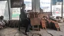 Pekerja menyelesaikan pembuatan rehal atau meja untuk Al-qur’an di Toko Mabruri 12, Klender, Jakarta, Rabu (13/4/2022). Harga rehal di toko ini dibanderol mulai dari Rp50.000 hingga Rp300 ribu per buah, tergantung ukuran dan jenis kayu. (merdeka.com/Iqbal S Nugroho)