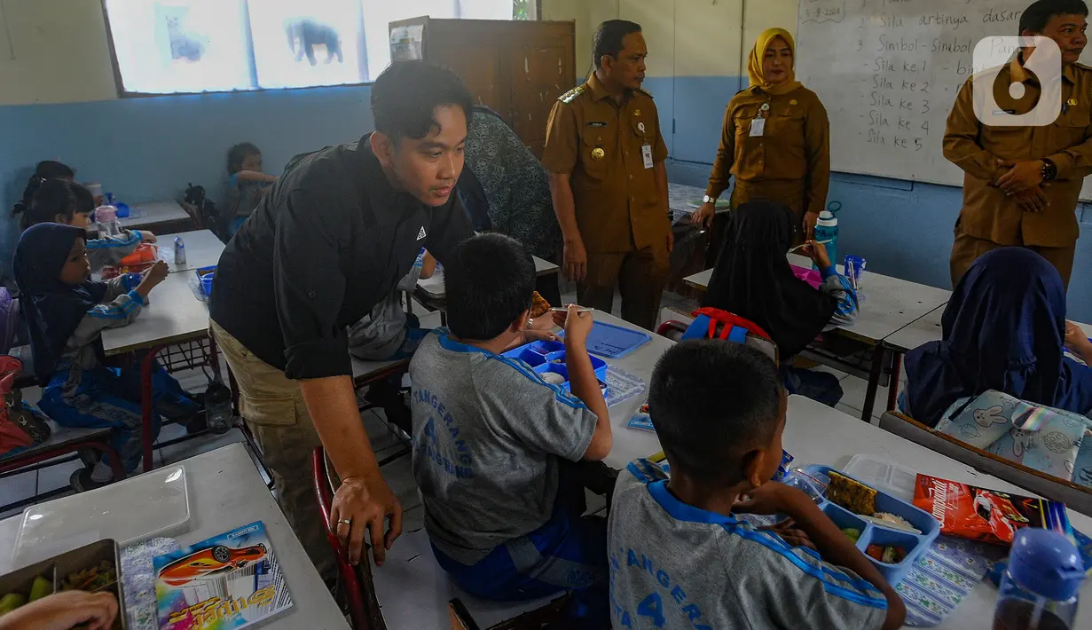 Wakil Presiden terpilih Gibran Rakabuming Raka berbincang dengan siswa saat meninjau uji coba pelaksanaan program makan bergizi gratis di SDN 4 Tangerang, Kota Tangerang, Banten, Senin (5/8/2024). (merdeka.com/Arie Basuki)