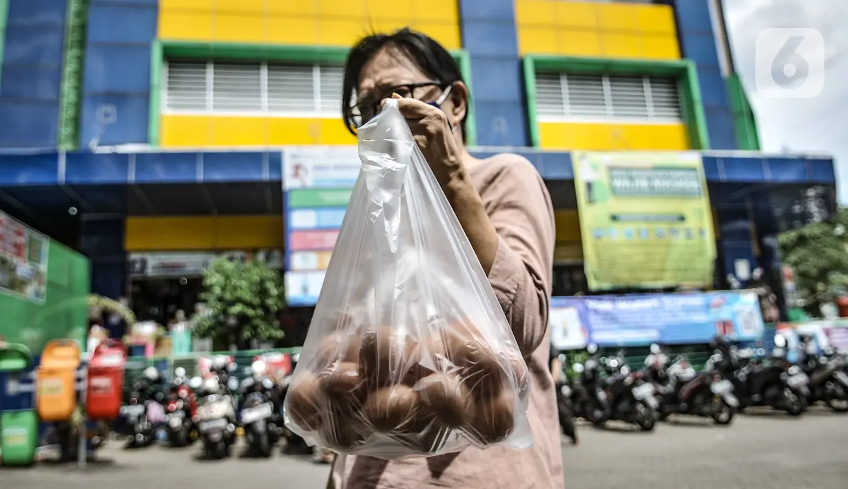 Warga menunjukkan paket telur 1 kilogram yang dibeli di Gelar Pangan Murah, Pasar Tebet Barat, Jakarta, Rabu (23/12/2020). Gelar Pangan Murah digelar guna mengantisipasi kenaikan harga jelang Natal dan Tahun Baru. (merdeka.com/Iqbal S. Nugroho)