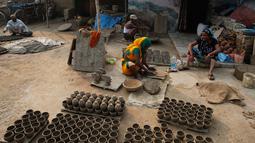 Pengrajin tembikar membuat lampu minyak yang terbuat dari tanah liat menjelang festival Diwali di Prayagraj, India, Kamis (17/10/2019).   Saat Diwali, seluruh kota akan dihiasi diya, lampu minyak tradisional yang terbuat dari tanah liat, lampion, dan lampu lainnya. (AP/Rajesh Kumar Singh)