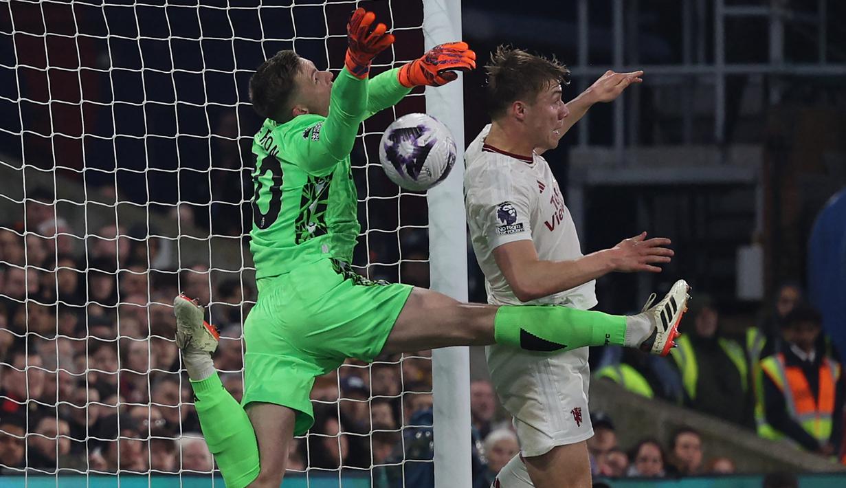Striker Manchester United #11 Rasmus Hojlund melakukan pelanggaran terhadap kiper Crystal Palace #30 Dean Henderson (kiri) saat merebut bola yang menyebabkan gol tersebut dianulir pada laga pekan ke-36 Premier League 2023/2024 di Selhurst Park, Selasa (7/5/2024) dini hari WIB. (Adrian DENNIS / AFP)