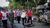 Wali Kota Solo, Gibran Rakabuming Raka berlari membawa obor Pospenas IX 2022, Selasa (22/11).(Liputan6com/Fajar Abrori)
