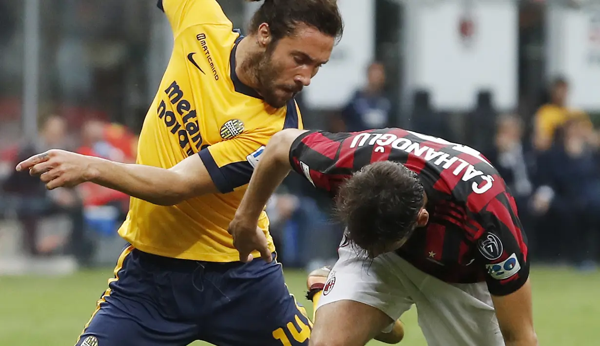 Pemain AC Milan, Hakan Calhanoglu (kanan) berebut bola dengan pemain Hellas Verona, Franco Zuculini pada lanjutan Serie A di San Siro stadium, Milan, (5/5/2018). AC Milan menang telak 4-1. (AP/Antonio Calanni)