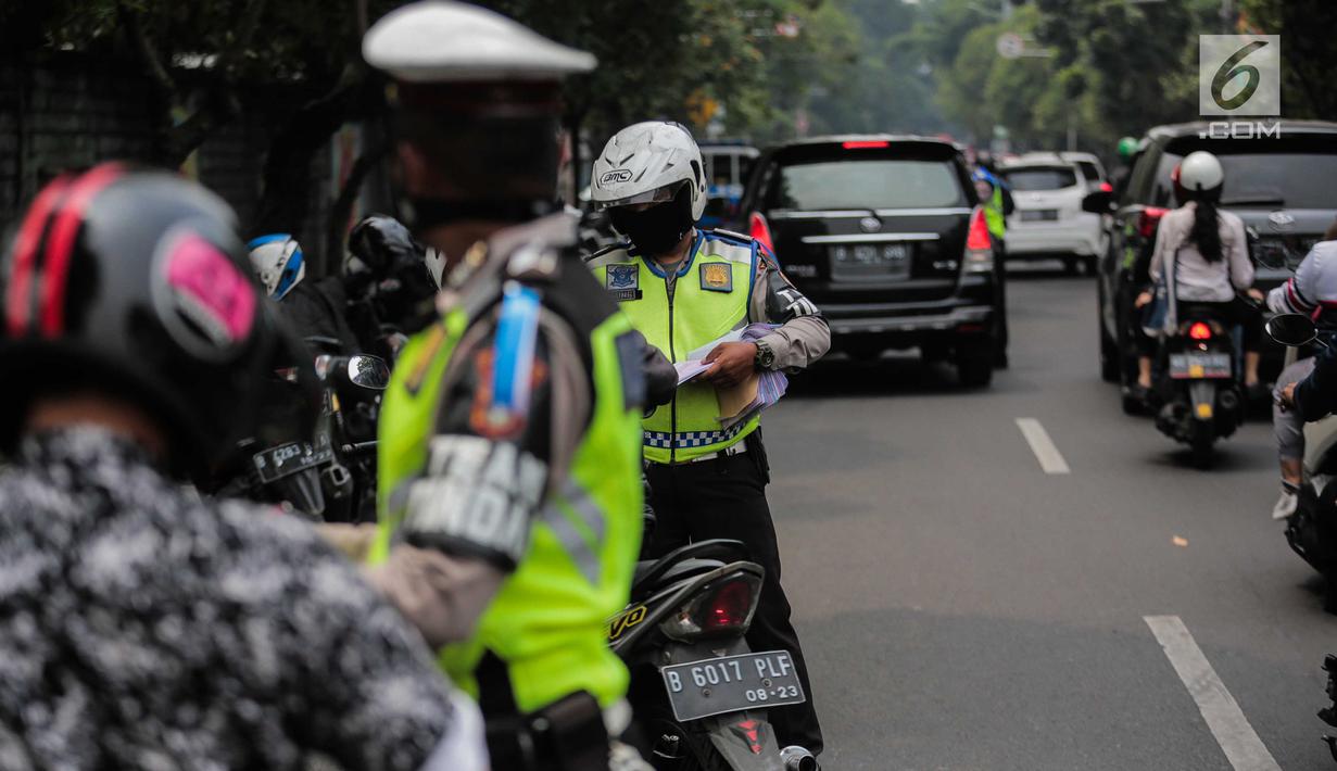 Polisi lalu lintas memeriksa kelengkapan surat pengendara saat razia Operasi Patuh Jaya 2019 di kawasan Kemanggisan, Jakarta, Kamis (29/8/2019). Operasi ini diharapkan dapat meningkatkan kepatuhan dan ketertiban dalam berlalu lintas serta mengurangi angka kecelakaan. (Liputan6.com/Faizal Fanani)