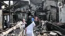 Warga menyaksikan kondisi rumah pasca kebakaran melanda permukiman padat penduduk di Jalan Cikini Kramat, RT 004 dan 015, RW 001, Kelurahan Pegangsaan, Kecamatan Menteng, Jakarta Pusat, Selasa (27/9/2022). Kebakaran yang terjadi sekitar pukul 04.35 tadi diduga berasal dari ledakan kompor gas pedagang bubur yang menyebabkan satu orang mengalami luka bakar dan puluhan rumah yang dihuni 75 kepala kepala keluarga ludes dilalap api. (merdeka.com/Iqbal S Nugroho)
