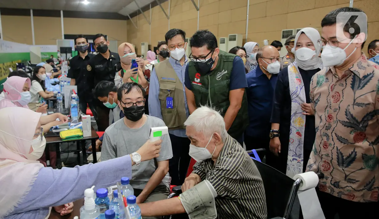 Menparekraf Sandiaga Uno (rompi hijau) didampingi jajaran ILUNI UI meninjau Sentra Vaksinasi Sinergi Sehat di The Media Hotel and Towers, Jakarta, Selasa (24/08/2021). Vaksinasi yang digelar hingga 7 September 2021 menyediakan 2.000 dosis vaksin per hari. (Liputan6.com/Fery Pradolo)