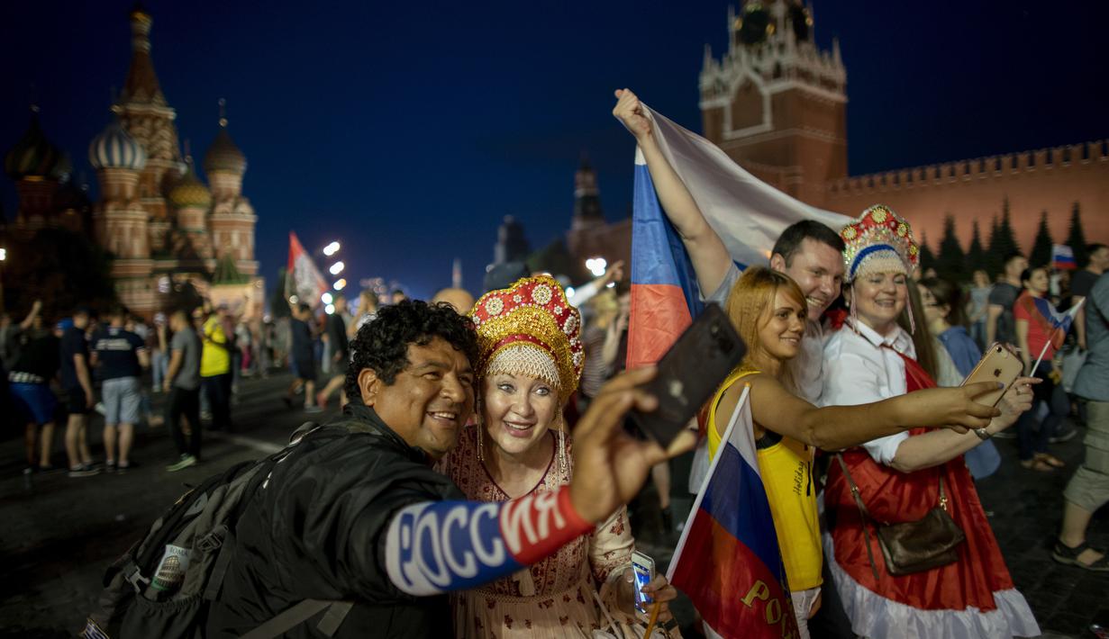 Suporter Rusia berpesta merayakan keberhasilan negaranya mengalahkan Spanyol pada laga 16 besar Piala Dunia di Moskow, Minggu (1/7/2018). Rusia untuk pertama kalinya lolos ke babak perempatfinal. (AFP/Victor Caivano)