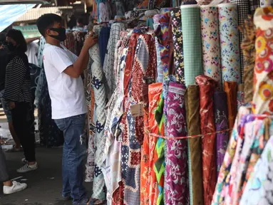 Aktivitas perdagangan tekstil di Pasar Cipadu, Tangerang, Senin (21/9/2020). Asosiasi Pertekstilan Indonesia (API) menyatakan industri Tekstil dan Produk Tekstil (TPT) sudah mulai beroperasi meski belum normal kembali akibat daya beli yang masih rendah di masa pandemi. (Liputan6.com/Angga Yuniar)