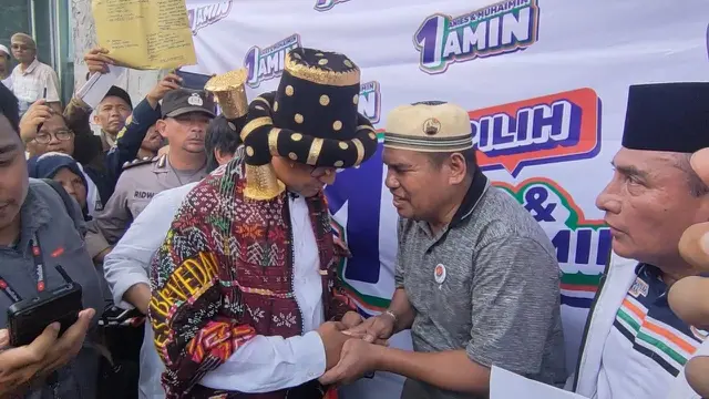 Capres nomor urut satu Anies Baswedan diberikan sejumlah uang oleh seorang pendukungnya saat kampanye akbar di Lapangan Istana Raja Najungal Tapanuli Selatan, Sumatera Utara, Kamis (1/2/2024). (Liputan6.com/Winda Nelfira)