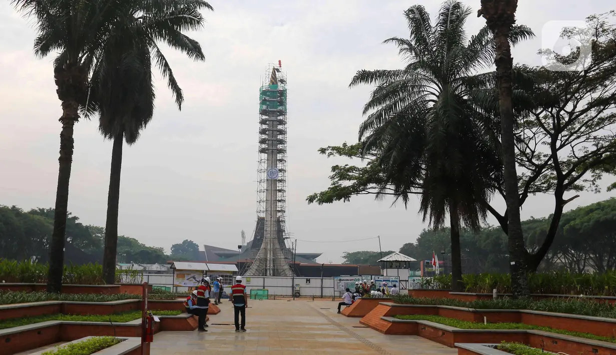 Pekerja menyelesaikan proyek revitalisasi Taman Mini Indonesia Indah (TMII), Jakarta Timur, Selasa (12/7/2022). Progres revitalisasi Taman Mini Indonesia Indah (TMII) secara fisik telah mencapai sekitar 70 hingga 80 persen dan ditargetkan rampung bulan ini. (Liputan6.com/Herman Zakharia)