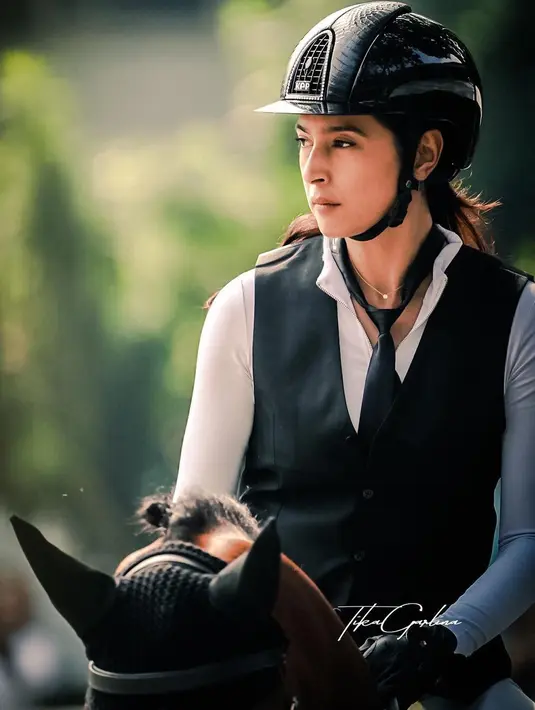 Nabila Syakieb memang dikenal punya hobi berkuda. Begini penampilan kerennya berbalut kaos putih, vest dan dasi hitam saat ikut kompetisi berkuda. [Foto: Instagram].