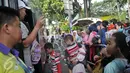 Penumpang antre menaiki bus tingkat wisata di depan halte Masjid Istiqlal, Jakarta, Minggu (30/4). Warga memanfaatkan hari libur panjang mereka dengan berkeliling Jakarta menggunakan bus tingkat ini secara gratis. (Liputan6.com/Yoppy Renato)