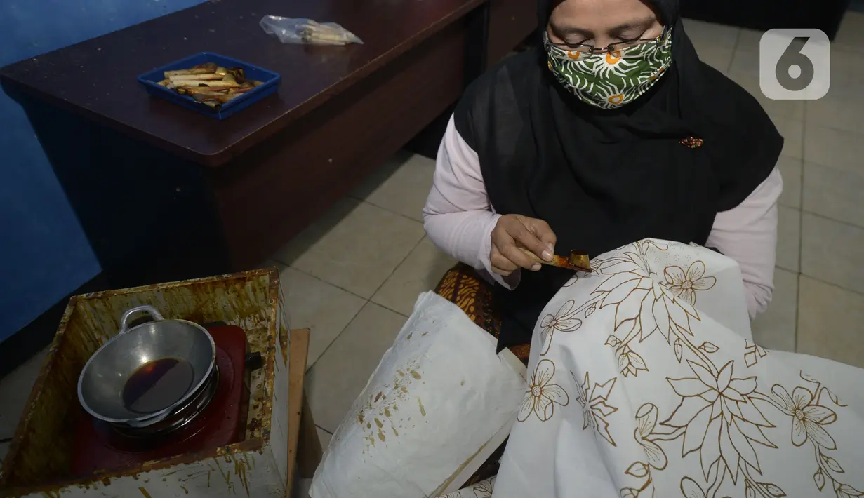 Ibu rumah tangga menyelesaikan pembuatan batik kembang mayang di Kampung Batik, Kelurahan Larangan Selatan, Kota Tangerang, Banten, Rabu (26/8/2020). Di tempat yang menjadi destinasi wisata tersebut kita bisa melihat langsung pembuatan dan mengikuti pelatihan membatik. (merdeka.com/Dwi Narwoko)