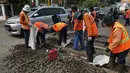 Sejumlah pengendara melitas di sebelah para pekerja yang sedang melakukan perawatan rutin rel kereta api di Manggarai, Jakarta, Selasa (11/7). Perawatan dan pengecekan tersebut guna menjamin keselamatan perjalanan kereta api. (Liputan6.com/Helmi Afandi)
