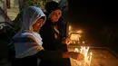 Umat Kristiani Irak menyalakan lilin setelah Misa Malam Natal di Gereja St. Joseph di Baghdad, Irak, Minggu (24/12). (AP Photo / Karim Kadim)