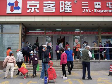 Orang-orang mengantre di luar supermarket untuk membeli persediaan makanan di Beijing pada 25 April 2022. Kekhawatiran penguncian Covid memicu pembelian panik dan antrean panjang untuk pengujian massal di Beijing pada 25 April ketika otoritas China bergegas untuk membasmi wabah di ibu kota. (AFP/Noel Celis)